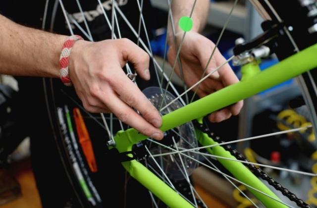 bicycle mechanic aligning rear bike wheel